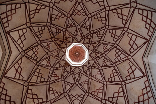 View of the geometric patterns adorning the ceiling with an octagonal skylight, showcasing the craftsmanship in Shahi Hammam, Lahore, Punjab, Pakistan.