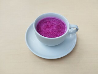 Dragon fruit juice in white cup on wooden table background. Healthy drink lifestyle 