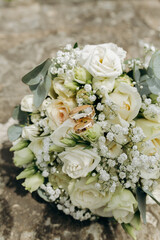 Wedding rings on white floral bridal bouquet, elegant wedding details