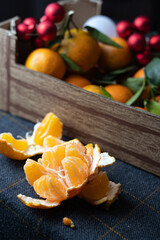 Vibrant market stall showcasing peeled mandarins with decorative holiday accents and lush foliage