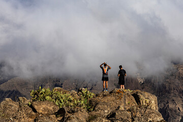 Hiker stands on the summit of Roque del Conde, Tenerife, Canary Islands.