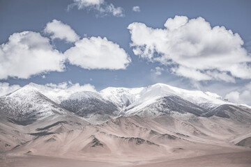 Landscape in the Pamir Mountains of Tajikistan with snow, glaciers, and cliffs, a panorama of mountains in cloudy weather for the background, nature in the Tien Shan highlands, landscape background