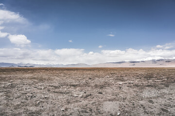 Landscape in the Pamir Mountains of Tajikistan with snow, glaciers, and cliffs, a panorama of mountains in cloudy weather for the background, nature in the Tien Shan highlands, landscape background