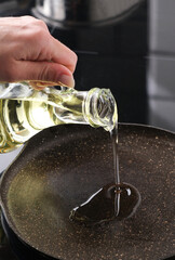 Girl Pouring Oil On A Hot Pan, Vertical View