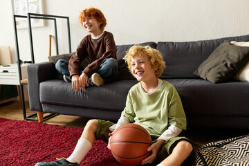 Joyful moments of redhead and blonde boys watching basketball game at home together