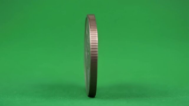 Ultra realistic silver coin standing upright with detailed engraved floral emblem against a vibrant green background perfect for finance and currency visuals