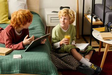 Joyful boys sharing stories and drinks in a modern apartment one cheerful afternoon