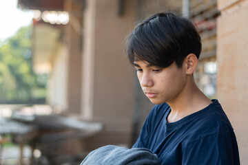 A quiet, melancholic moment. A middle school teenagd boy, wearing a grey hooded sweatshirt, stands alone with a sad, introspective expression. Capturing feelings of solitude and youthful contemplation