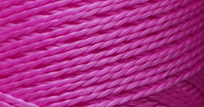 Pink Thread Macro. Extreme close-up of bright pink sewing thread strands gently moving and catching light in a repeating pattern.	
