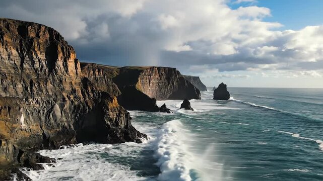Dramatic Cliffs of Moher in Ireland with crashing waves and moody skies.