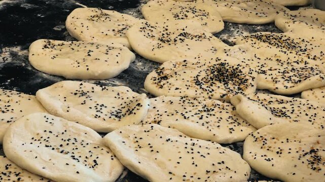 Buns with seed before baking. The process of making bread in a kitchen. High quality 4k footage