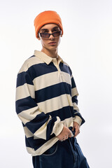 Stylish teenager showcases unique fashion vibes in striped polo with orange hat