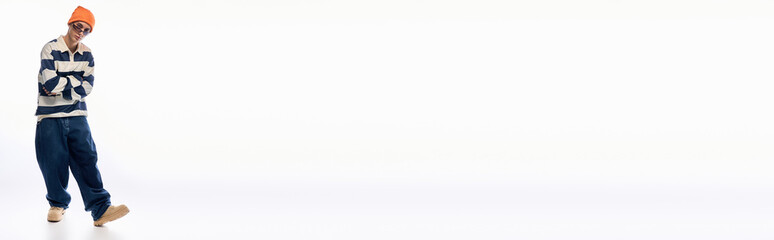 Stylish teenager expresses individuality in striped polo and bright orange hat