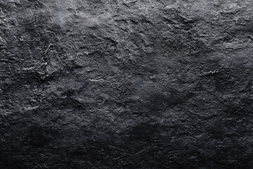 a dark textured abstract background resembling rough stone or slate