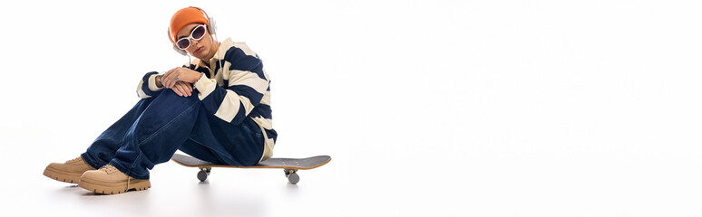 Stylish teenager showcases fashion and confidence on a skateboard background
