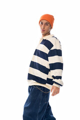 Stylish teenager showcases Gen Z fashion in a striped polo with an orange hat