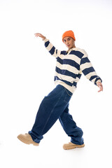 Stylish teenager showcases trendy outfit with vibrant orange hat and striped polo