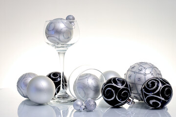 Black and silver colored Christmas balls  on reflective surface