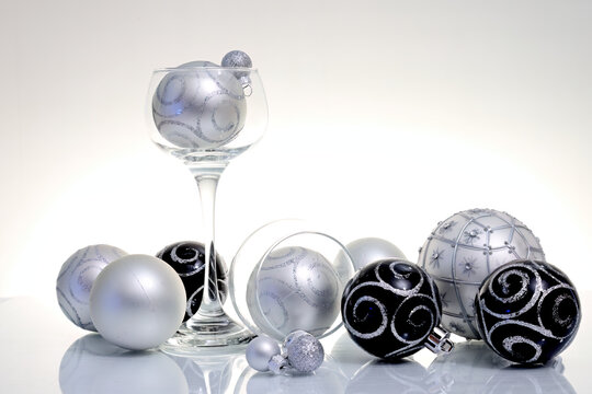 Black and silver colored Christmas balls  on reflective surface