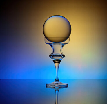 Glass ball on a candle holder with colorful background