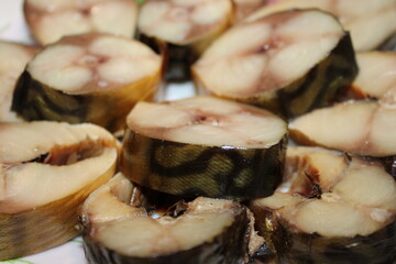 Fish slices ready for serving on a plate with a focus on the texture and pattern of the fish