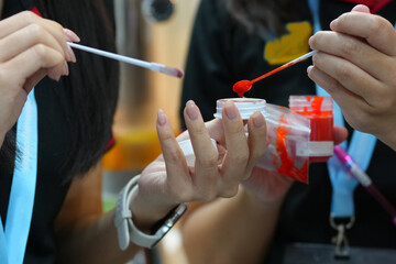 close-up of a woman's hand testing lip colors.