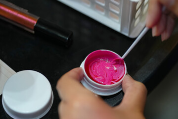 close-up of a woman's hand testing lip colors.