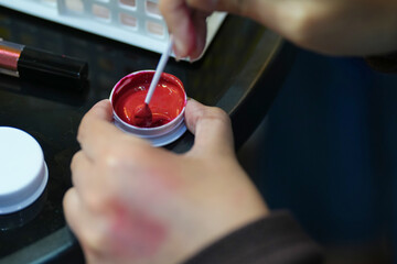 close-up of a woman's hand testing lip colors.