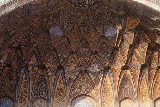 View of the intricate mosaic ceiling, adorned with geometric patterns and calligraphy, casting shadows in Dehli Gate, Lahore, Punjab, Pakistan.