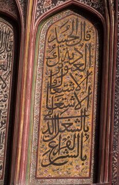 View of intricate Arabic calligraphy artfully adorns a textured wall, with vibrant colors creating a striking contrast in Dehli Gate, Lahore, Punjab, Pakistan.