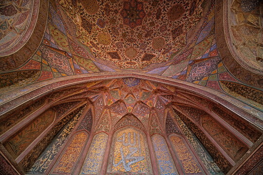 View of a mesmerizing mosaic of geometric patterns and ornate calligraphy adorning the arched ceiling, a symphony of color and artistry, Lahore, Punjab, Pakistan.