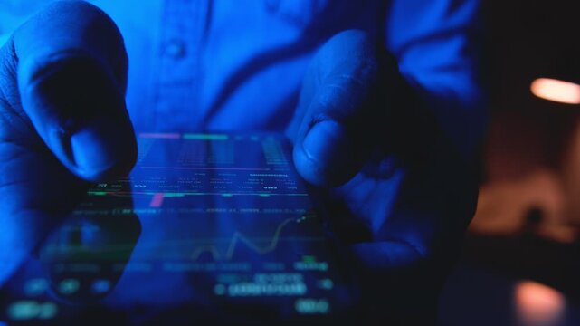 Close-up of a trader's hands buying and selling stocks online using a mobile phone application