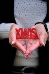 Frauenh&auml;nde mit der Schrift "XMAS" halten rot
