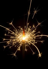 Bright golden sparkler bursts with radiant sparks against black background for festive, holiday, or celebration use

