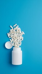 Clean Pharmaceutical Image of White Pill Bottle Spilling Capsules on Blue Surface - Top View Ecommerce Concept with Space for Text