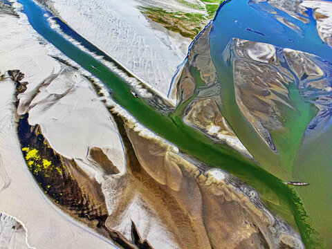 Aerial view of a river dividing into multiple streams with contrasting colors of water and sand, creating an abstract landscape, Bogura, Rajshahi Division, Bangladesh.