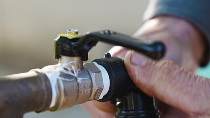 man is holding pipe with angled fitting and adjusting plastic valve. process of plumbing repair, including insulation, gasket replacement, pipes, and faucets.