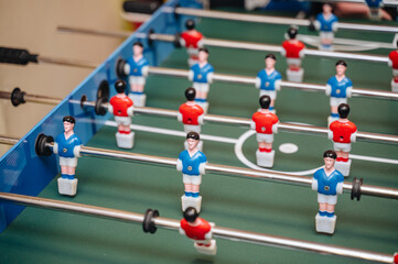 Close-up of players on a table football game (foosball), symbolizing competition, teamwork, and leisure activity