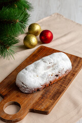 Christmas Stollen Bread made at home with Dried Fruit on a Wooden Board, side view.