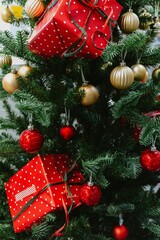 A decorated Christmas tree featuring red and gold ornaments alongside two red gift boxes wrapped in white polka dot paper with green and red ribbons.