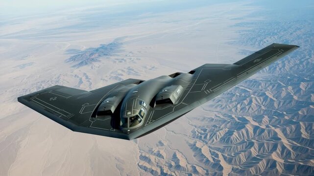 A stealthy b-2 spirit bomber soaring silently over a vast desert mountain range
