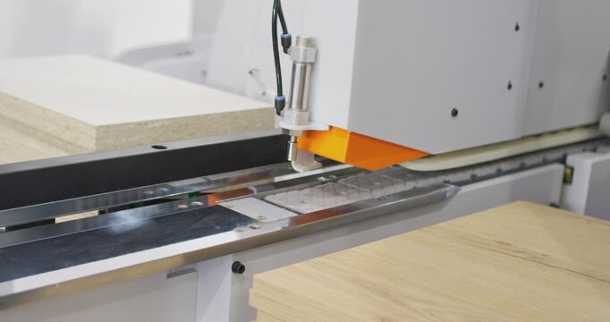 Industrial woodworking machine processing a furniture board
