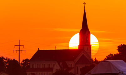 Obraz premium Megazoom (600mm) summer sunset or sundowner with a church silhouette near Otzing, Deggendorf, Bavaria, Germany