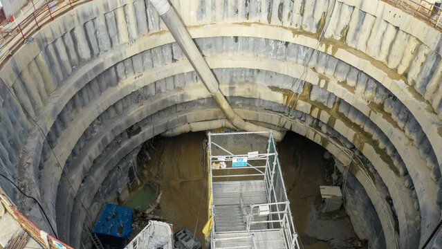 Aerial view of a construction site with a deep, circular excavation, revealing layered concrete walls and scaffolding, Istanbul, İstanbul, Turkey.