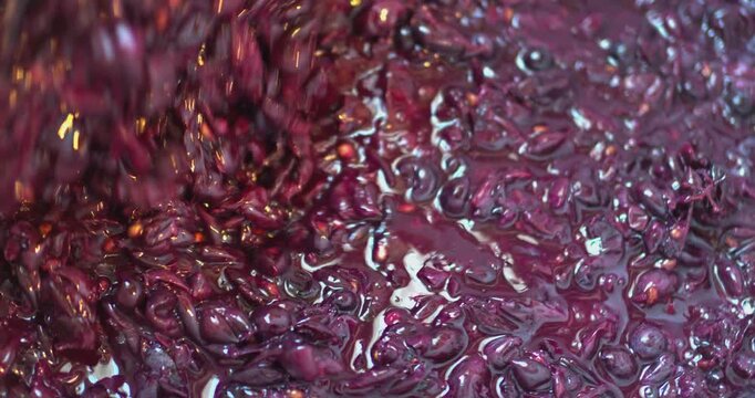 Winemaker stirring crushed grapes for red wine fermentation