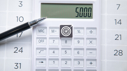 Achieve goals. Calculator, pen and calendar.