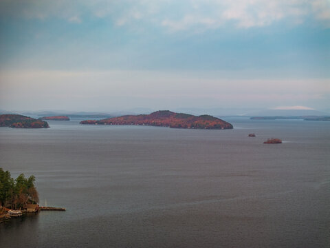 Aerial view of islands scattered across the serene waters, autumn colors painting the landscape with hues of red and gold, Alton, New Hampshire, United States.