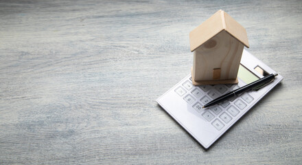 House model, calculator and pen on the table. Real estate