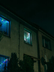 Residential House Windows with Christmas Lights at Night, Cozy Home Interior Glow and Quiet Urban Neighborhood