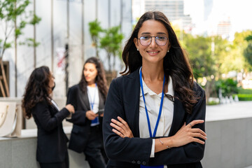 Confident businesswoman taking a selfie outdoors while holding a coffee cup, representing modern corporate lifestyle, social media engagement, and professional confidence in an urban environment.